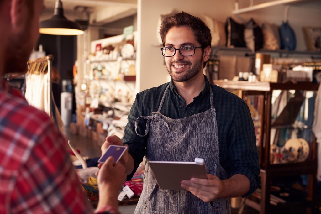man getting the credit card from the customer