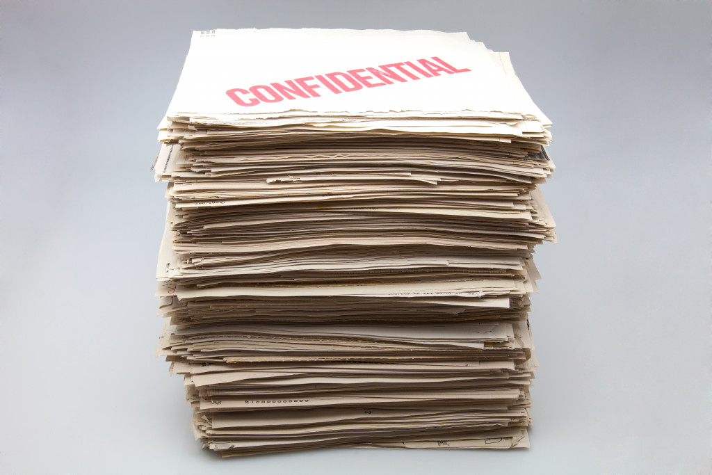 A stack of papers with a red Confidential stamp on top